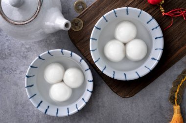Yeni yıl festivali yemekleri için büyük tangyuan yuanosunun (glutinous rice dumpling balls) en üst görüntüsü, altın sikkenin üzerindeki kelimeler onun yaptığı hanedan adı anlamına gelir..