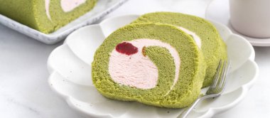 Lezzetli kirazlı rulo pasta dilimleri beyaz arka planda çilekli krema, yakın plan..