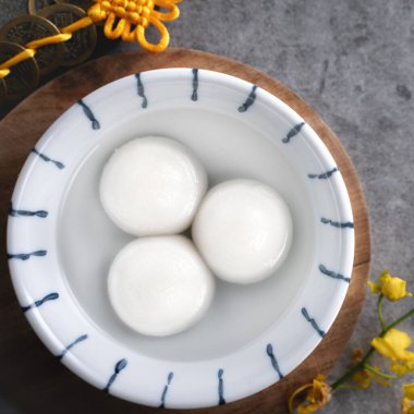 Yeni yıl festivali yemekleri için büyük tangyuan yuanosunun (glutinous rice dumpling balls) en üst görüntüsü, altın sikkenin üzerindeki kelimeler onun yaptığı hanedan adı anlamına gelir..
