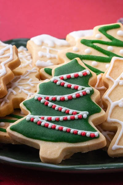 赤いテーブルの上のプレートにクリスマスの装飾された砂糖のクッキーの終わり — ストック写真