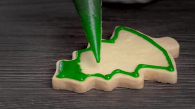Yeşil kremalı ahşap masa arkasına zencefilli Noel ağacı şekeri çiz. Bayram kutlaması kavramı..