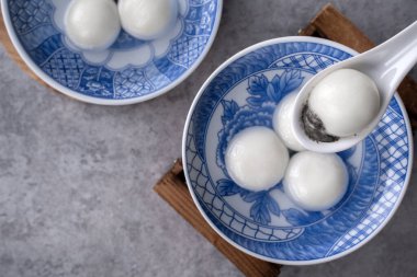 Yeni yıl festivali yemekleri için büyük tangyuan yuanosunun (glutinous rice dumpling balls) en üst görüntüsü, altın sikkenin üzerindeki kelimeler onun yaptığı hanedan adı anlamına gelir..