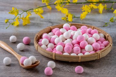 Çiğ kırmızı ve beyaz tangyuan glutinous pirinç köfteleri, kış gündönümü festivali için ahşap masa arkasında..