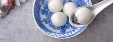 Yeni yıl festivali yemekleri için büyük tangyuan yuanosunun (glutinous rice dumpling balls) en üst görüntüsü, altın sikkenin üzerindeki kelimeler onun yaptığı hanedan adı anlamına gelir..