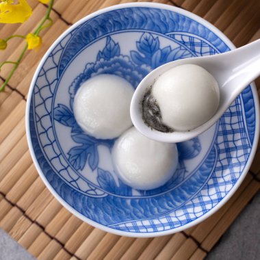 Yeni yıl festivali yemekleri için büyük tangyuan yuanosunun (glutinous rice dumpling balls) en üst görüntüsü, altın sikkenin üzerindeki kelimeler onun yaptığı hanedan adı anlamına gelir..