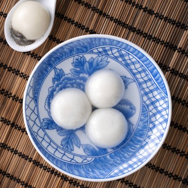 Yeni yıl festivali yemekleri için büyük tangyuan yuanosunun (glutinous rice dumpling balls) en üst görüntüsü, altın sikkenin üzerindeki kelimeler onun yaptığı hanedan adı anlamına gelir..