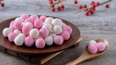 Çiğ kırmızı ve beyaz tangyuan glutinous pirinç köfteleri, kış gündönümü festivali için ahşap masa arkasında..