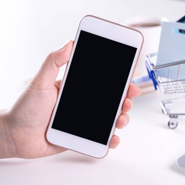 Akıllı cep telefonu kullanan bir kadın evde elektronik ödeme yapıyor.