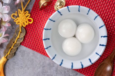 Çin Yeni Yıl Festivali yemekleri için büyük tangyuan yuanosunun (glutinous rice dumpling balls) en üst görüntüsü, altın sikke üzerindeki kelimeler onun yaptığı hanedan adı anlamına gelir..
