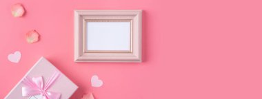 Pembe arka planda pembe taç yaprakları ve hediye kutusu olan Sevgililer Günü tasarımı konsepti