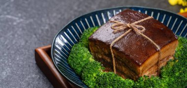 Dong Po Rou (Dongpo domuz eti) yeşil brokoli sebzeli güzel bir mavi tabakta, Çin 'in yeni yıl yemeği için geleneksel şenlikli yemekler, kapatın..