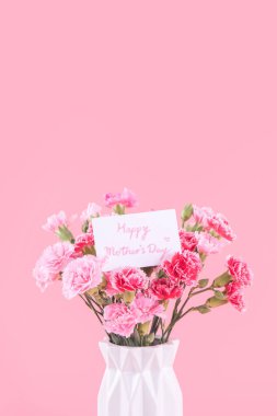 Anneler Günü hediye tasarımı, pembe karanfilli çiçek buketi, açık pembe arka planda izole edilmiş, kopyalama alanı..