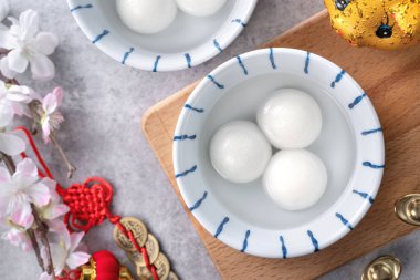 Çin Yeni Yıl Festivali yemekleri için büyük tangyuan yuanosunun (glutinous rice dumpling balls) en üst görüntüsü, altın sikke üzerindeki kelimeler onun yaptığı hanedan adı anlamına gelir..