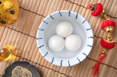 Çin Yeni Yıl Festivali yemekleri için büyük tangyuan yuanosunun (glutinous rice dumpling balls) en üst görüntüsü, altın sikke üzerindeki kelimeler onun yaptığı hanedan adı anlamına gelir..