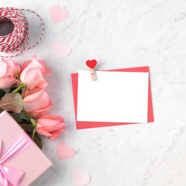Sevgililer Günü tasarım konsepti pembe gül çiçeği, hediye kutusu ve mermer beyaz arka planda kart
