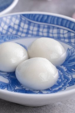 Yuanao Tangyuan 'ın (glutinous rice dumpling balls) kapağı gri bir masada çiçekli, Çin Feneri Yuthe Festivali için yemek.