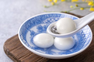Yuanao Tangyuan 'ın (glutinous rice dumpling balls) kapağı gri bir masada çiçekli, Çin Feneri Yuthe Festivali için yemek.