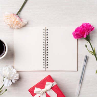 Anneler Günü 'nün dizayn birleşimi karanfil çiçeği, bayram hediyesi fikri ve annemin masa arkasında defter günlüğü..