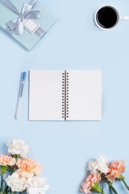 Anneler Günü 'nün dizayn birleşimi karanfil çiçeği, bayram hediyesi fikri ve annemin masa arkasında defter günlüğü..