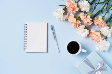 Anneler Günü 'nün dizayn birleşimi karanfil çiçeği, bayram hediyesi fikri ve annemin masa arkasında defter günlüğü..