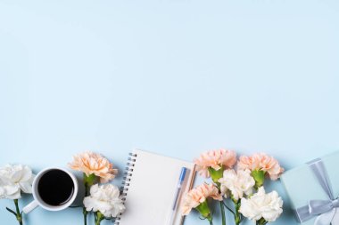 Anneler Günü 'nün dizayn birleşimi karanfil çiçeği, bayram hediyesi fikri ve annemin masa arkasında defter günlüğü..