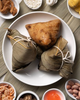 Zongzi. Ejderha Teknesi Duanwu Festivali için ahşap masa üstü manzaralı lezzetli geleneksel pirinç köftesi..