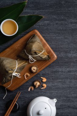 Zongzi. Çin geleneksel Ejderha Tekne Festivali (Duanwu Festivali) için siyah arka plan üzerine pirinç köfteli hamur tatlısı tasarımı konsepti.