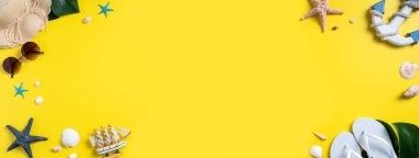 Yaz sahili tasarımı konsepti. Deniz kabukları, şapka, sarı arka planda terlik ile tatil seyahatinin en üst görüntüsü.