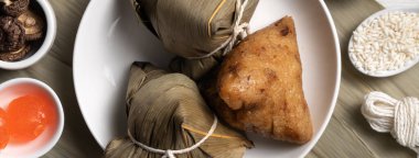 Zongzi. Ejderha Teknesi Duanwu Festivali için ahşap masa üstü manzaralı lezzetli geleneksel pirinç köftesi..