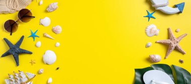 Yaz sahili tasarımı konsepti. Deniz kabukları, şapka, sarı arka planda terlik ile tatil seyahatinin en üst görüntüsü.