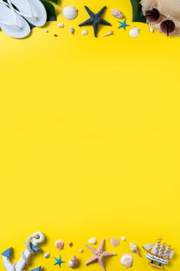 Yaz sahili tasarımı konsepti. Deniz kabukları, şapka, sarı arka planda terlik ile tatil seyahatinin en üst görüntüsü.