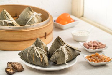 Zongzi. Geleneksel Çin Ejderha Tekne Festivali (Duanwu Festivali) için pirinç köftesi pencere önü açık ahşap masa arkaplanı üzerine.