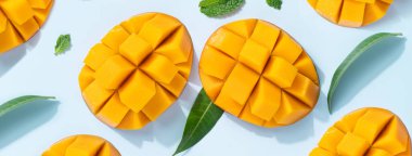 Mango tasarım konsepti. Mavi masa arkasında doğranmış taze mango meyvesi desenlerinin üst görüntüsü.