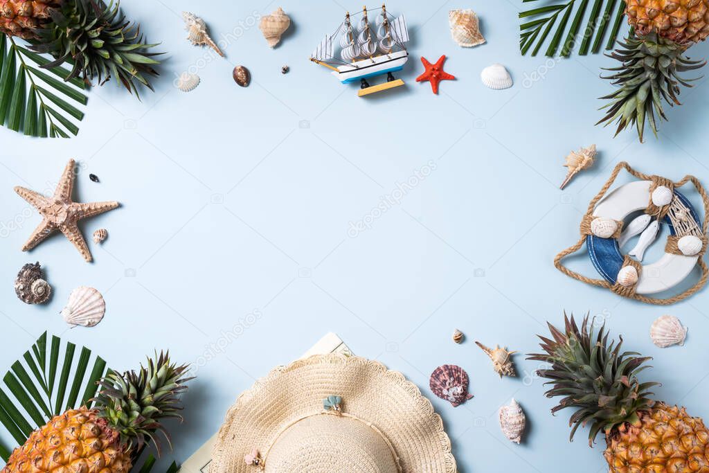 Summer fruit background design concept. Top view of holiday travel beach with shells, hat, pineapple and palm leaves on blue background.
