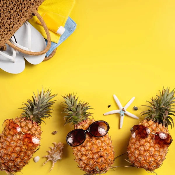 Yaz meyvesi tasarımı konsepti. Deniz kabukları, ananas ve sarı arka planda palmiye yaprakları olan tatil gezilerinin en iyi manzarası..