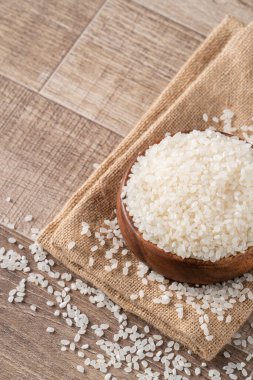 Çiğ beyaz cilalanmış yenilebilir pirinç ahşap masa arkasında, organik tasarım konsepti..