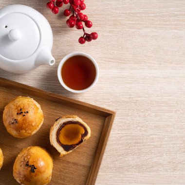 Top view tasarım konsepti: Ay pastası sarısı pastası, Sonbahar Festivali için ay çöreği, ahşap masa arkasında tatil.