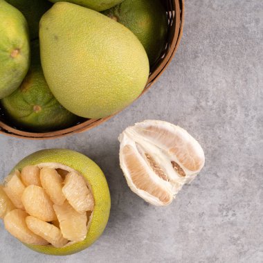 Gri çimento masa arkaplanındaki taze pomelo manzarası.