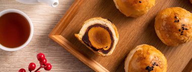 Top view tasarım konsepti: Ay pastası sarısı pastası, Sonbahar Festivali için ay çöreği, ahşap masa arkasında tatil.