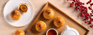 Top view tasarım konsepti: Ay pastası sarısı pastası, Sonbahar Festivali için ay çöreği, ahşap masa arkasında tatil.