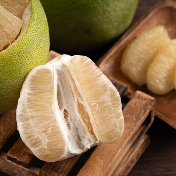 Close up of fresh peeled pomelo on wooden table background for Mid-Autumn Festival fruit.