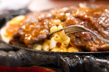 Tayvan usulü sıcak biftek, erişte, yumurta ve sos ve sıcak demir tabakta..