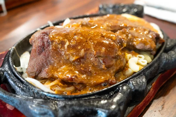 Tayvan usulü sıcak biftek, erişte, yumurta ve sos ve sıcak demir tabakta..