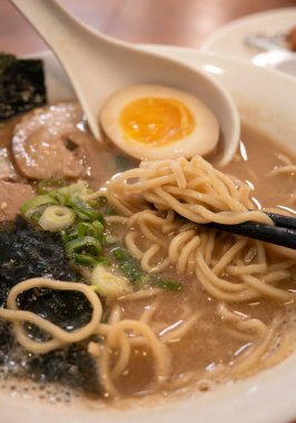 Rich tonkotsu ramen with char siu, soft-boiled egg, and seaweed in a savory broth.