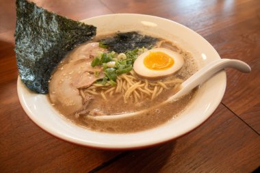 Rich tonkotsu ramen with char siu, soft-boiled egg, and seaweed in a savory broth.