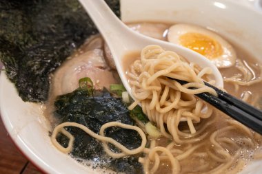 Rich tonkotsu ramen with char siu, soft-boiled egg, and seaweed in a savory broth.