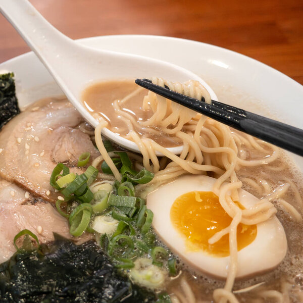 Rich tonkotsu ramen with char siu, soft-boiled egg, and seaweed in a savory broth.