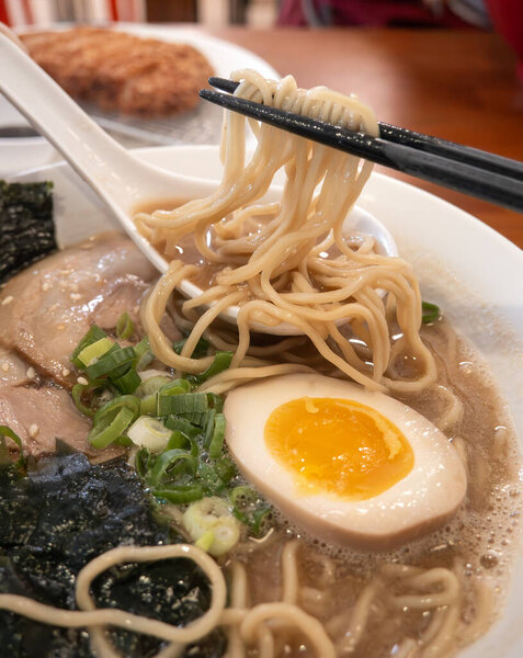 Rich tonkotsu ramen with char siu, soft-boiled egg, and seaweed in a savory broth.