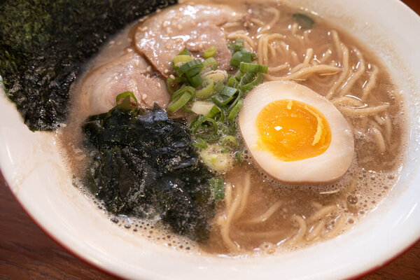 Rich tonkotsu ramen with char siu, soft-boiled egg, and seaweed in a savory broth.