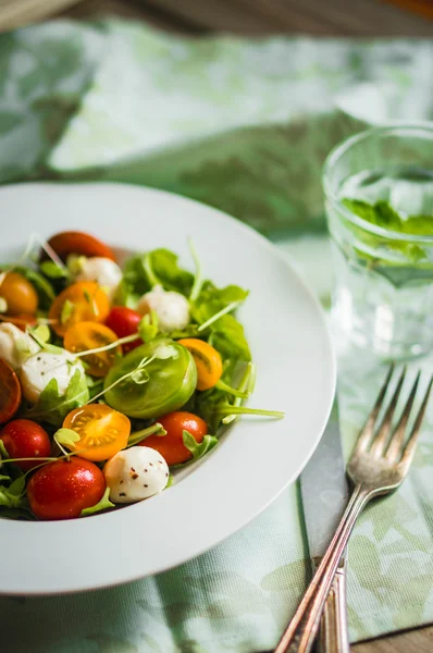 Roka, domates ve mozarella ahşap arka plan üzerinde salatası — Stok fotoğraf